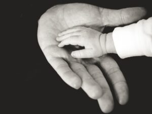 Adult and baby hands in black and white.